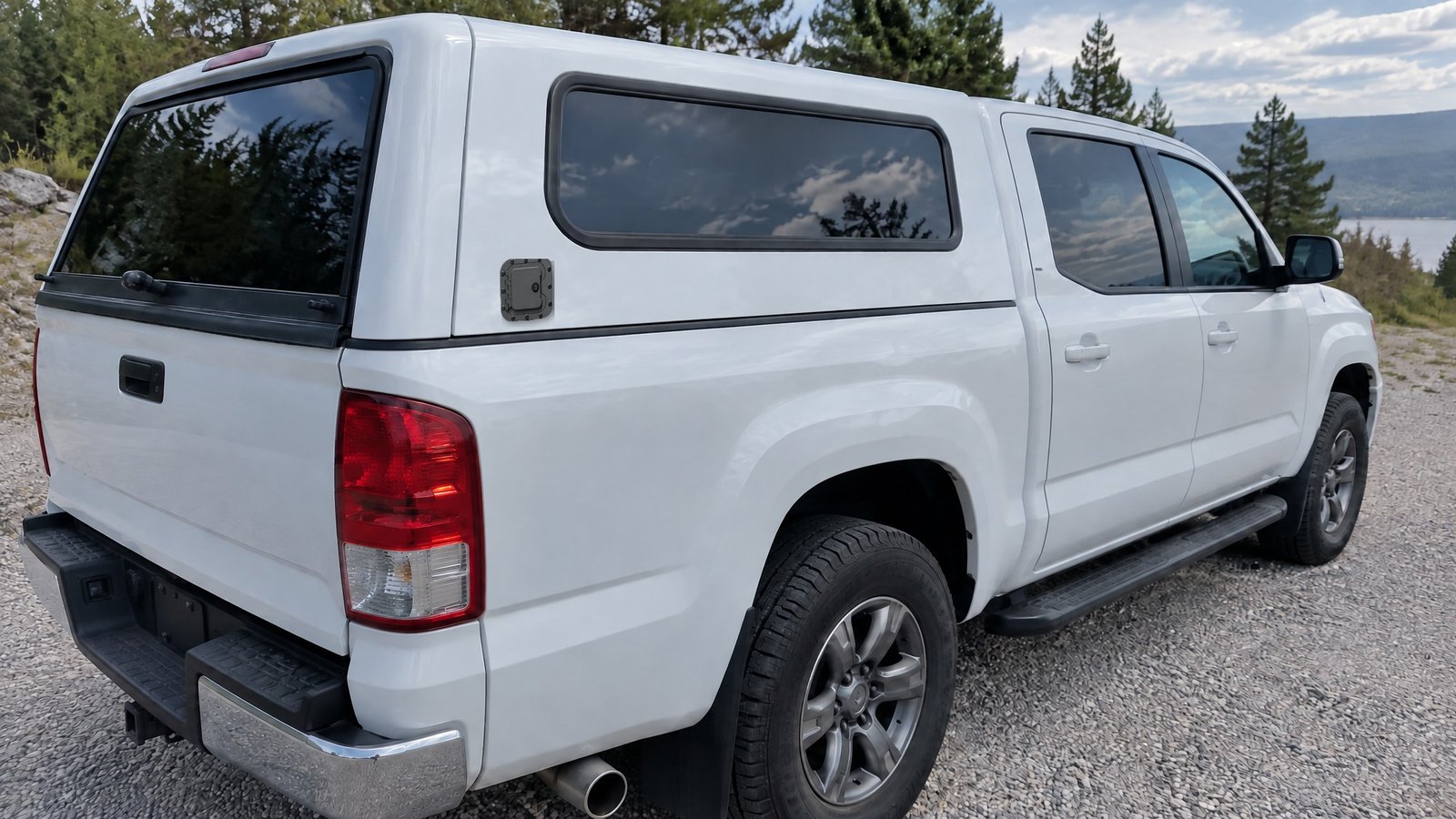 Locking hatch door mounted on the side of a pickup truck cap topper